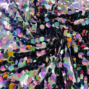 May include: A fabric material covered in circular, iridescent sequins that shift between shades of black, purple, blue, and green. The sequins are densely layered and attached to a sheer, light-colored mesh backing, creating a reflective surface.