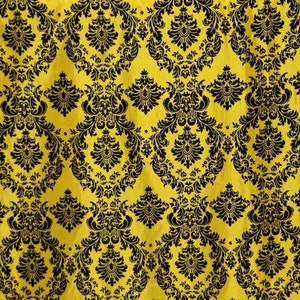May include: A seamless pattern of black damask designs on a yellow background. The pattern is intricate and detailed, with a repeating motif of swirling leaves and flowers.