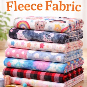 May include: A stack of colorful fleece fabric rolls with various patterns, including rainbows, bears, and polka dots. The image includes the text "Cozy Fleece Fabric" and "Soft & High Quality". Accessories like scissors and spools of thread are also visible.