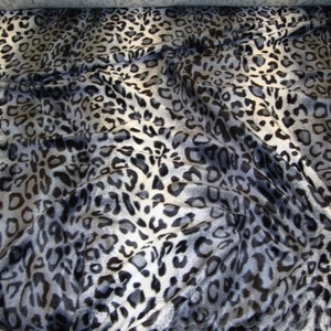 May include: Black and white leopard print fabric with a blue and gray ombre effect.