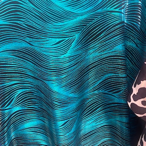 Turquoise waves on black Nylon Spandex print fabric.
