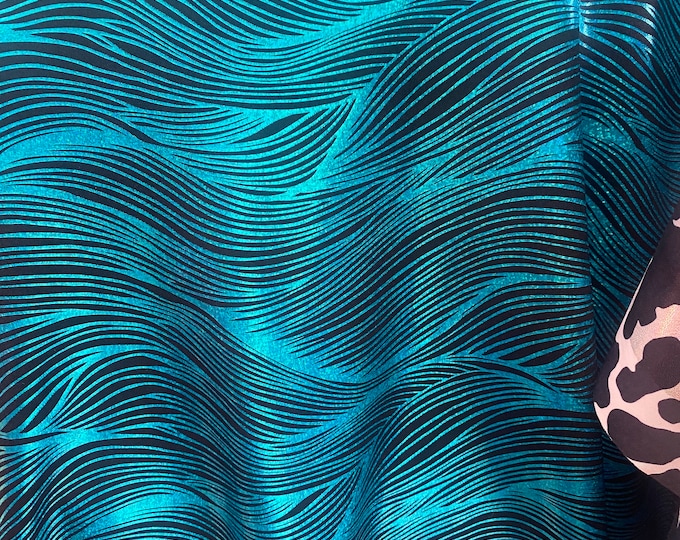 Turquoise waves on black Nylon Spandex print fabric.