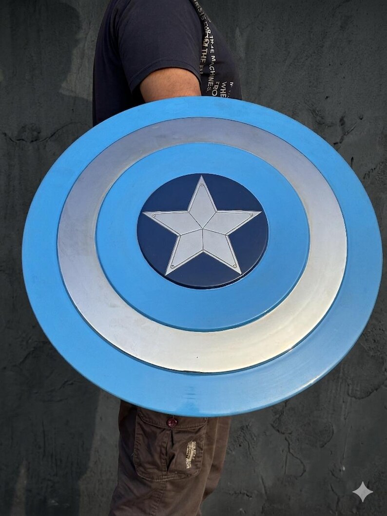 May include: A blue, silver, and white shield with a central star design. The shield has a circular shape with concentric rings of colour. The centre is dark blue with a white star.
