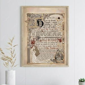 May include: Framed artwork with an antique aesthetic. The print features ornate calligraphy, illustrations, and text from "The Prophecy." Dominant colors are beige, brown, and red. The artwork is displayed on a wooden table with decorative items.