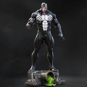 Może przedstawiać: Szczegółowa statua postaci Venom z komiksów Marvela. Postać jest przeważnie czarna z białymi akcentami na klatce piersiowej i plecach. Statua ma długi, czerwony język i stoi na podstawie przypominającej kanał z zielonym płynem.