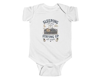 May include: White baby bodysuit featuring the text "Sleeping all day, staying up all night." The design includes a crib, moon, stars, clouds, and bottles. The bodysuit is made of soft fabric and has short sleeves.