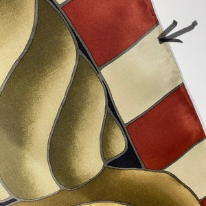 May include: A silk scarf with a geometric pattern in shades of brown, beige, red, and black. The scarf has a fringed edge.