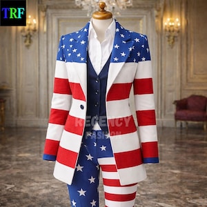 May include: A patriotic suit featuring the American flag design. The jacket has red and white stripes with a blue top section adorned with white stars. The matching pants are blue with white stars. A navy vest and white shirt complete the ensemble. The text "REGENCY FASHION" is visible.