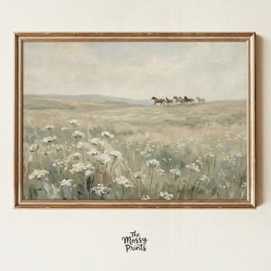 Puede incluir: Una impresión enmarcada de estilo vintage representa un campo de flores silvestres con una manada de caballos corriendo en la distancia. La obra de arte tiene una paleta de colores apagados de verdes, blancos y marrones, con un marco dorado. La impresión es de "The Mossy Prints".
