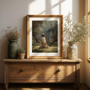 Peut inclure: Une impression encadr&eacute;e d'une sc&egrave;ne religieuse. L'&oelig;uvre repr&eacute;sente une figure agenouill&eacute;e dans une zone herbeuse, regardant vers le haut vers une lumi&egrave;re vive. L'impression est dans un cadre dor&eacute; et est expos&eacute;e sur un meuble en bois avec des vases d&eacute;coratifs.