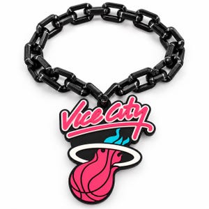 May include: A black chain link bracelet featuring a pendant with the text Vice City in pink script above a stylized basketball graphic in pink, white, and light blue. The pendant has a black background and is attached to the thick black chain links.