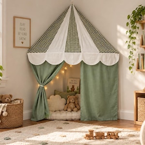Pode incluir: Uma tenda de brincar de canto com um telhado cónico de painéis alternados em xadrez verde e branco, rematado com um volante festonado branco. A tenda tem cortinas de cor verde sálvia sólido presas para revelar um interior almofadado.