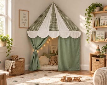 Può includere: Una tenda da gioco ad angolo con un baldacchino a quadri verdi e bianchi con bordo smerlato e tende in tinta unita verde salvia. L'interno è illuminato da luci a corda e contiene un cuscino a forma di nuvola e un orsacchiotto.
