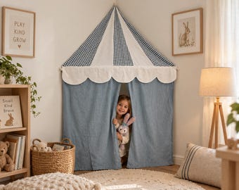 Può includere: Una tenda da gioco angolare con un tetto conico a quadretti vichy blu e bianchi e un bordo smerlato bianco. La tenda presenta pannelli in tessuto blu tinta unita che scendono fino a terra, creando un ingresso per un bambino.