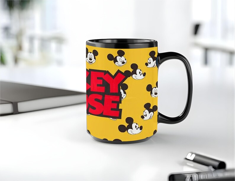 Peut inclure: Un mug en c&eacute;ramique jaune avec une anse et un bord noirs, orn&eacute; d'un motif r&eacute;p&eacute;titif de visages de Mickey Mouse et du texte rouge en gras MICKEY MOUSE sur le c&ocirc;t&eacute;. Le mug pr&eacute;sente une forme cylindrique et une finition brillante.