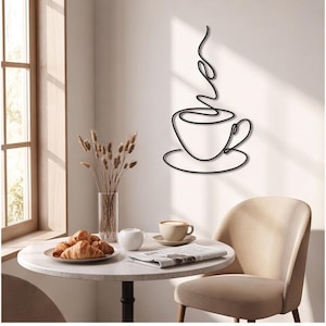 Può includere: Un'opera d'arte da parete in metallo nero che presenta un disegno a linea continua di una tazza di caffè su un piattino con vapore che sale. Il design è composto da un unico contorno in filo nero fluido che forma la tazza, il manico e il vapore.