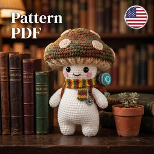 May include: A crocheted mushroom figure with a smiling face, wearing a colorful scarf and backpack. The mushroom has a brown and green cap with white spots. The text "Pattern PDF" is in the upper left corner.