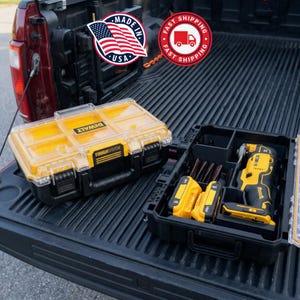 May include: Two black and yellow ToughSystem toolboxes with clear lids. One toolbox is closed, and the other is open, revealing a yellow and black oscillating multi-tool, batteries, and blades. The image includes a "Made in USA" sticker.