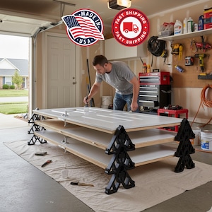 May include: A person painting a white door in a garage. The door is resting on a stack of three doors supported by black sawhorse style supports. The image includes a "Made in USA" sticker and a "Fast Shipping" sticker.