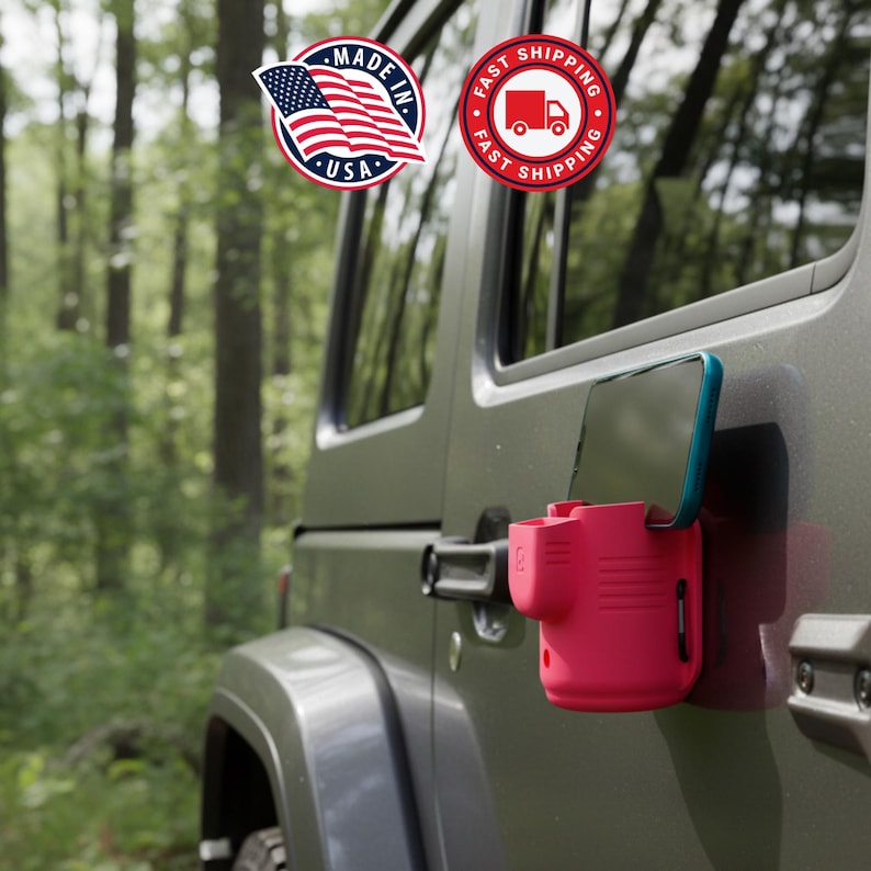 May include: A red phone holder attached to a green vehicle door. The phone holder has a teal-colored phone in it. The image includes a "Made in USA" sticker and a "Fast Shipping" sticker.