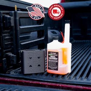 May include: A black container with a geometric design and a white and orange diesel treatment bottle. The bottle has a black cap and a label that reads "Diesel Treatment". The image also includes "Made in USA" and "Fast Shipping" stickers.