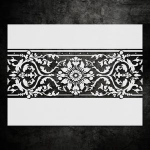 May include: A white rectangular card with a black floral design. The design features a central flower motif surrounded by swirling leaves and vines. The floral pattern is framed by two black horizontal bands.
