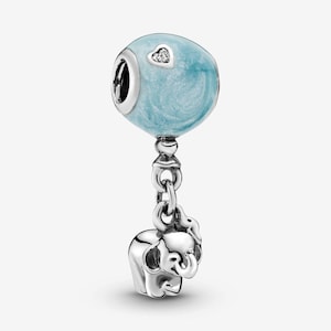 Può includere: Un charm in argento con una perla sferica azzurra con un accento a forma di cuore con diamante. Un piccolo charm a forma di elefante in argento è appeso sotto, collegato da una catena. Il charm è progettato per un braccialetto o una collana.