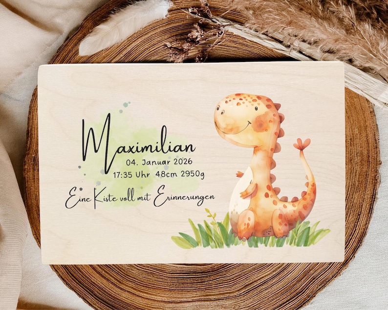 May include: Wooden keepsake box with a watercolor illustration of a friendly orange dinosaur. The box is personalized with the name "Maximilian", date, time, length (48cm), and weight (2950g) in black script.