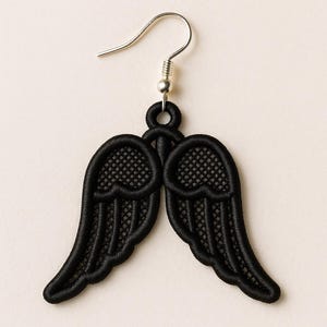 May include: A single black earring featuring a pair of embroidered wings. The wings are detailed with a mesh-like pattern and a solid black outline. The earring has a silver-colored hook.