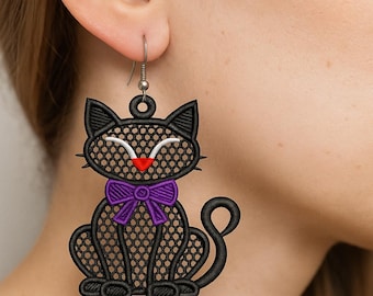 May include: Black cat earrings with a purple bow tie and red nose. The earrings are made of a black, open-weave material. The cat's face has white accents and a smiling expression. The earrings are hanging from a silver hook.
