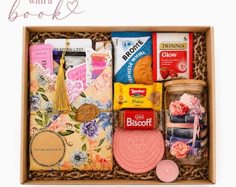 May include: A gift box containing a book wrapped in floral paper with a gold tassel, a pack of Bronte biscuits, Twinings Glow tea, Loacker lemon wafers, a Biscoff cookie, a pink woven coaster, a small pink candle, and a glass jar with floral book art.