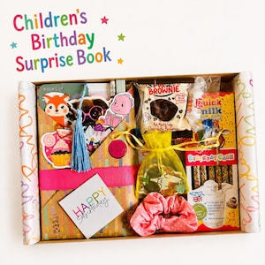 Puede incluir: Una caja de regalo de cartón que contiene un libro sorpresa de cumpleaños para niños, un brownie de chocolate, una pajita Quick Milk, una bolsa de organza amarilla con objetos pequeños, un coletero rosa de lunares y una tarjeta Happy Birthday.