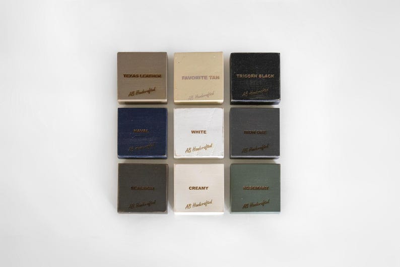 Puede incluir: Nueve muestras cuadradas de cuero en varios colores, incluyendo "Texas Leather", "Favorite Tan" y "Tricorn Black". Cada muestra tiene texto y las palabras "AB Handcrafted" en una fuente cursiva. Las muestras est&aacute;n dispuestas en una cuadr&iacute;cula de 3x3.