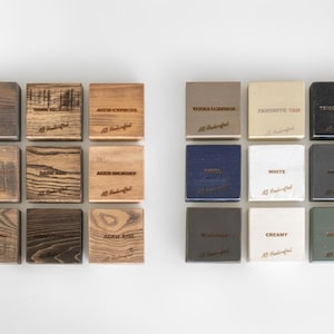 Puede incluir: Vista cenital de una cuadr&iacute;cula de peque&ntilde;os bloques cuadrados, algunos de madera y otros pintados. Los bloques muestran diferentes vetas de madera y colores, con etiquetas como "Texas Leather" y "Tricorn Black".