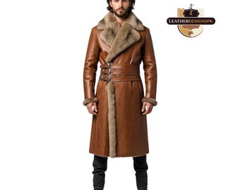 May include: A long, brown leather coat with a fur collar and trim. The coat features a belted waist with decorative buckles and fur cuffs. The coat is worn over black pants and brown boots. The logo "LEATHERDESIGNSPK" is visible.