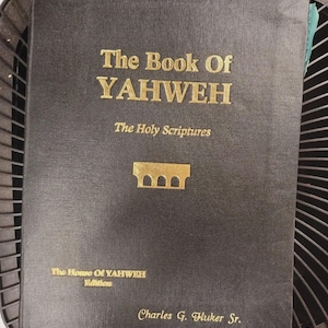 Pode incluir: Um livro preto com letras douradas. O título é "The Book Of YAHWEH" e "The Holy Scriptures". A capa também inclui "The House Of YAHWEH Editions" e o nome "Charles G. Fluker Sr."