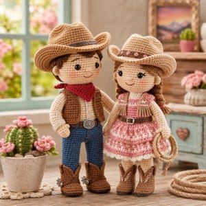 May include: Two crocheted cowboy dolls, a boy and a girl, stand side-by-side. The boy doll wears a brown vest, blue jeans, and a red bandana. The girl doll wears a pink dress and holds a rope. Both dolls wear cowboy hats and boots.