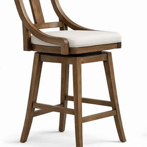 Könnte beinhalten: Ein Barhocker aus Holz mit einem hell gepolsterten Sitz und einer geschwungenen Rückenlehne. Der Hocker hat ein vierbeiniges Gestell mit Fußstütze und einen Drehsitz. Das Holz hat eine warme, natürliche Oberfläche, und das Sitzkissen ist neutral gefärbt.