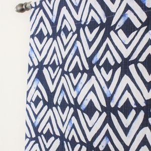 May include: A navy blue curtain panel with a white geometric pattern. The pattern is made up of repeating diamond shapes with white zig-zag lines.