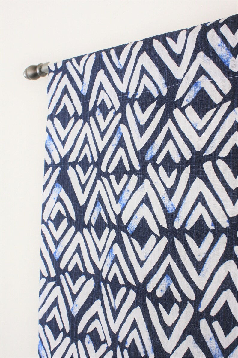 May include: A navy blue curtain panel with a white geometric pattern. The pattern is made up of repeating diamond shapes with white zig-zag lines.