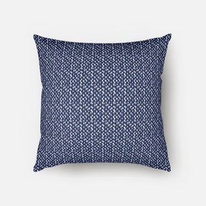 May include: A navy blue throw pillow with a white and blue geometric pattern.