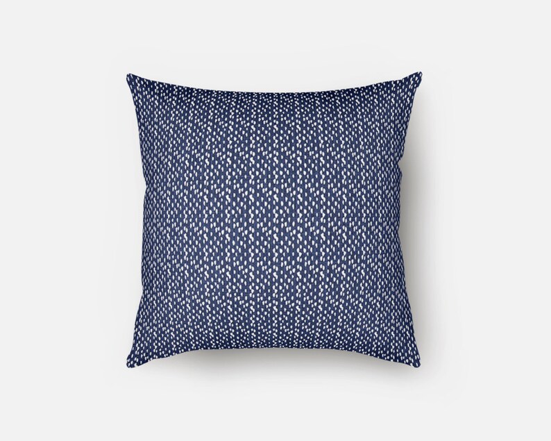 May include: A navy blue throw pillow with a white and blue geometric pattern.