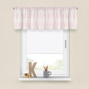 May include: A pink and white gingham valance with frills hangs on a window. The window is white and has a white sill. On the sill are a wooden letter K, a cup with pencils, and a gold ring.