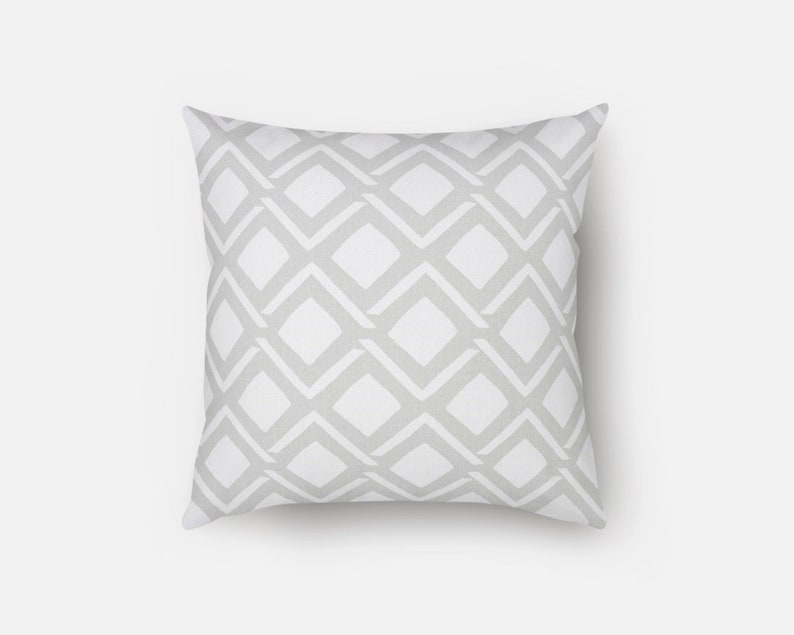 May include: A white cushion with a grey diamond pattern.
