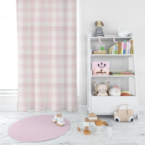 May include: A white bookshelf with four shelves, filled with books, toys, and storage boxes. The bookshelf is in a room with a pink and white gingham curtain and a pink and white chevron rug.