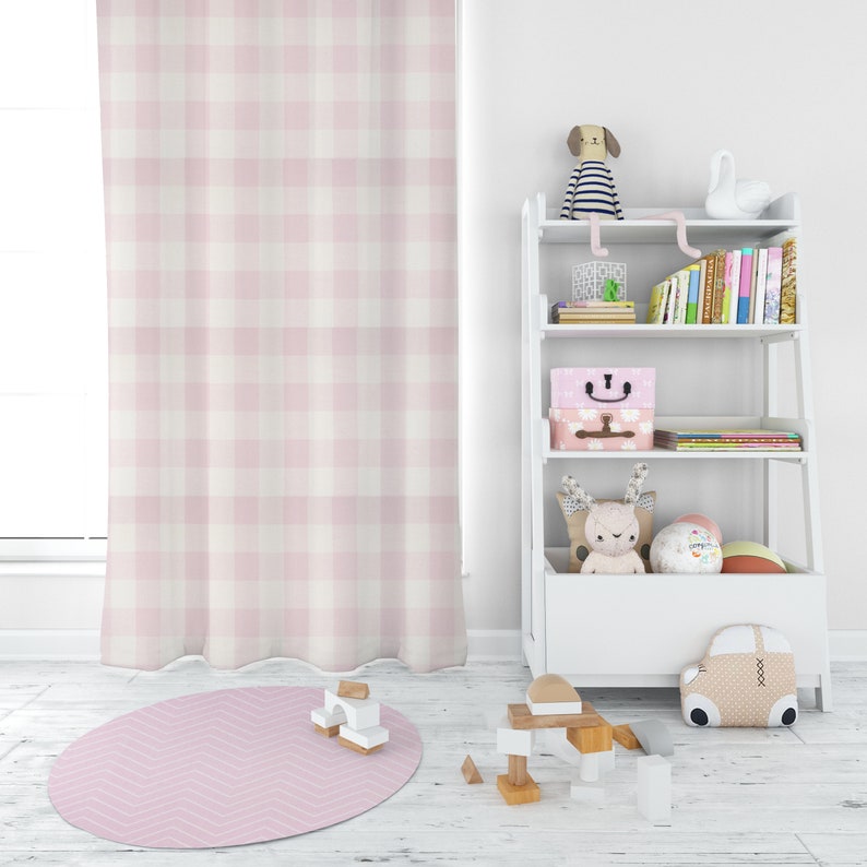 May include: A white bookshelf with four shelves, filled with books, toys, and storage boxes. The bookshelf is in a room with a pink and white gingham curtain and a pink and white chevron rug.