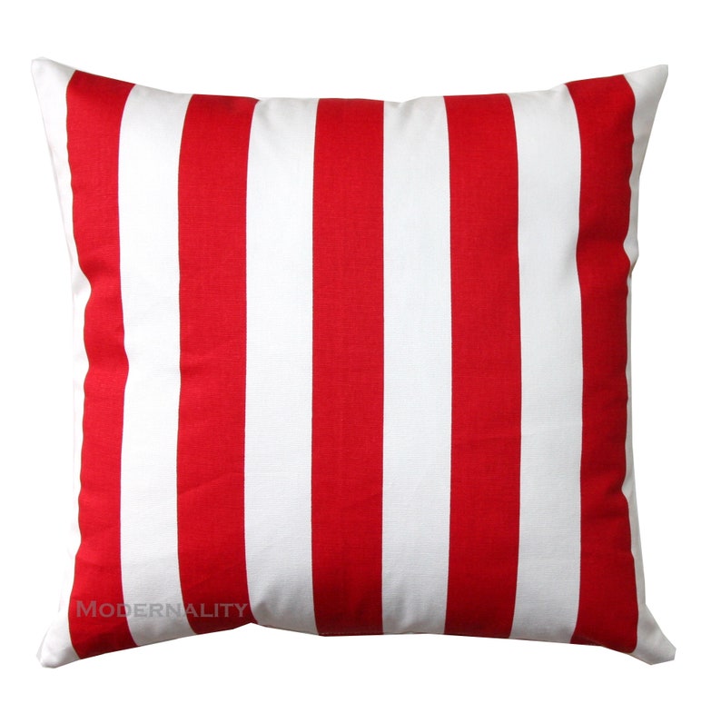 May include: Red and white striped throw pillow. The pillow is made of a soft, comfortable fabric and has a classic striped design.