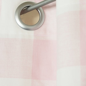 May include: Close-up of a pink and white gingham curtain with a silver eyelet and rod.