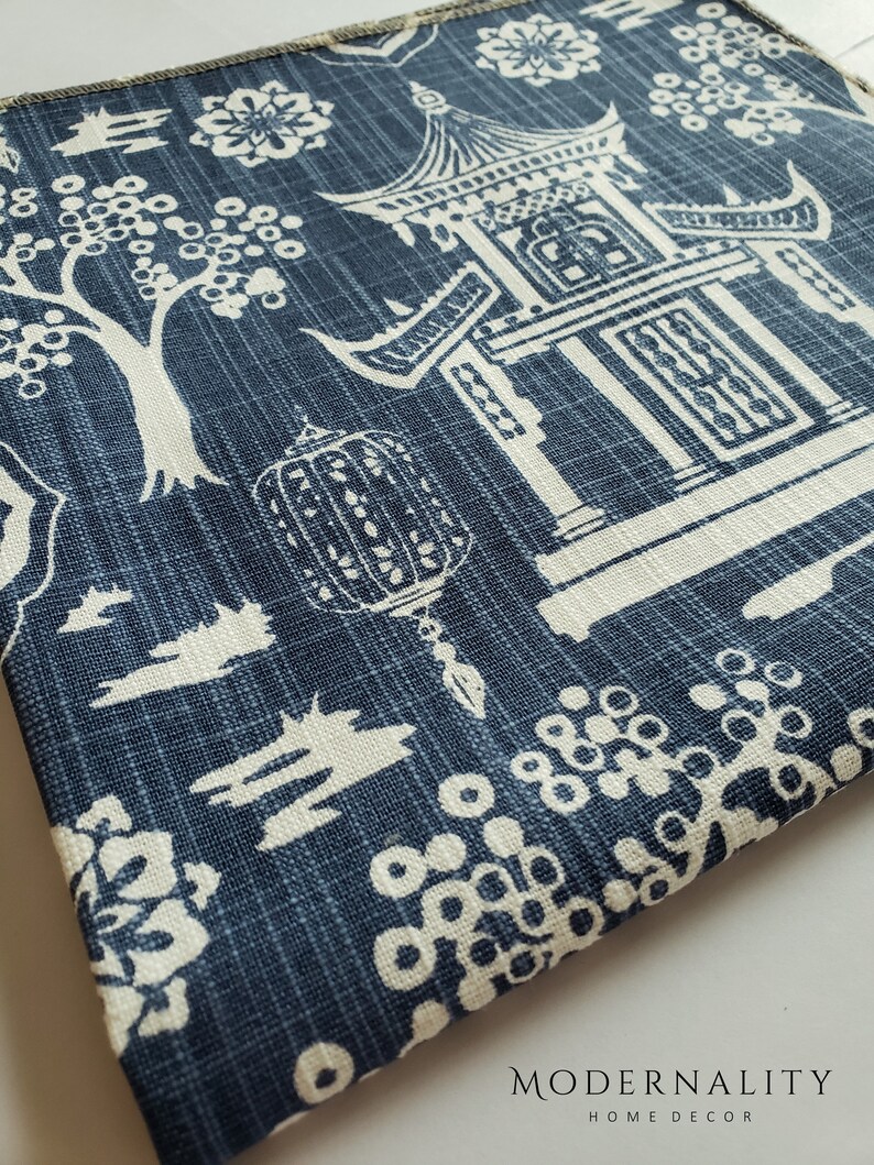 May include: Blue fabric with a white design of a pagoda, trees, and flowers. The fabric has a textured, linen-like appearance. The text "MODERNALITY HOME DECOR" is visible at the bottom of the image.
