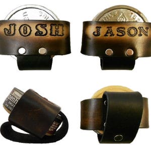 May include: Two brown leather can holders with metal rivets. The holders are personalized with the names "JOSH" and "JASON". A third holder is shown with a brown leather can holder with a black strap.
